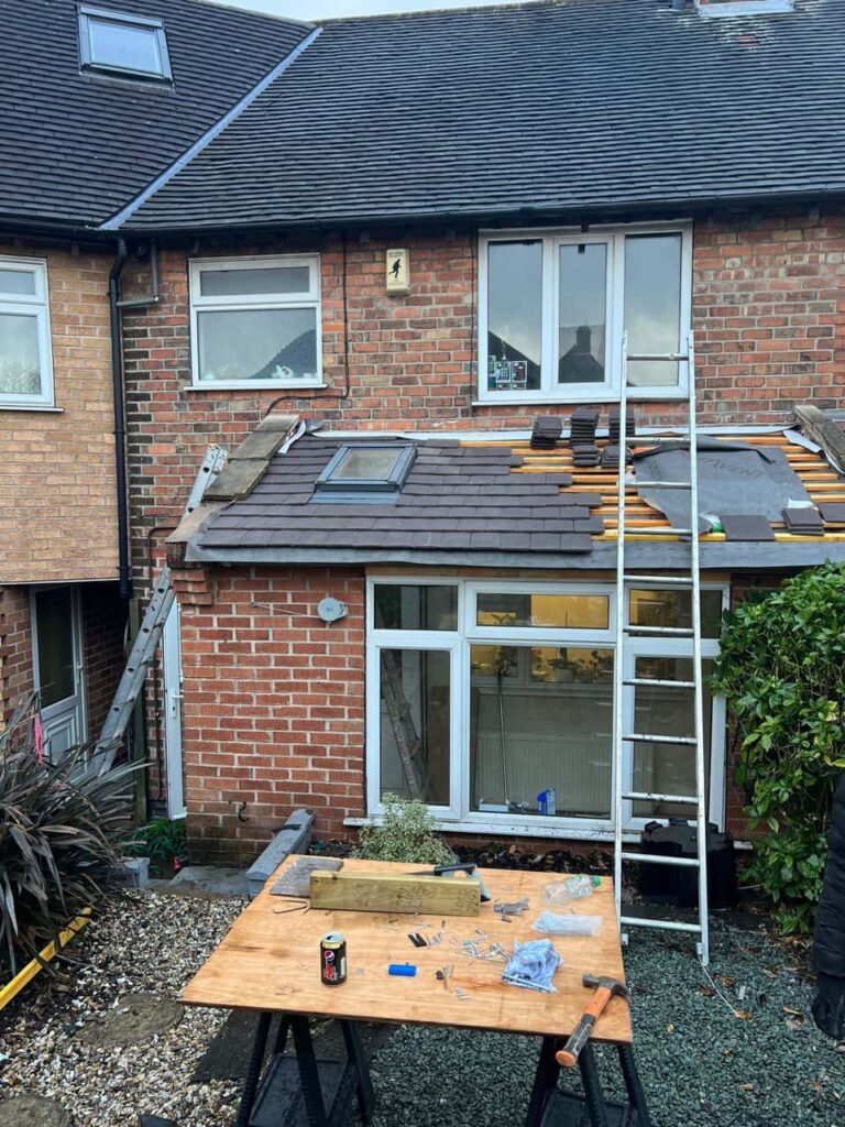 This is a photo of a roof extension that is having new roof tiles installed. This is a photo taken from the roof ridge looking down a tiled pitched roof on to a flat roof. Works carried out by Mildenhall Roofing Repairs