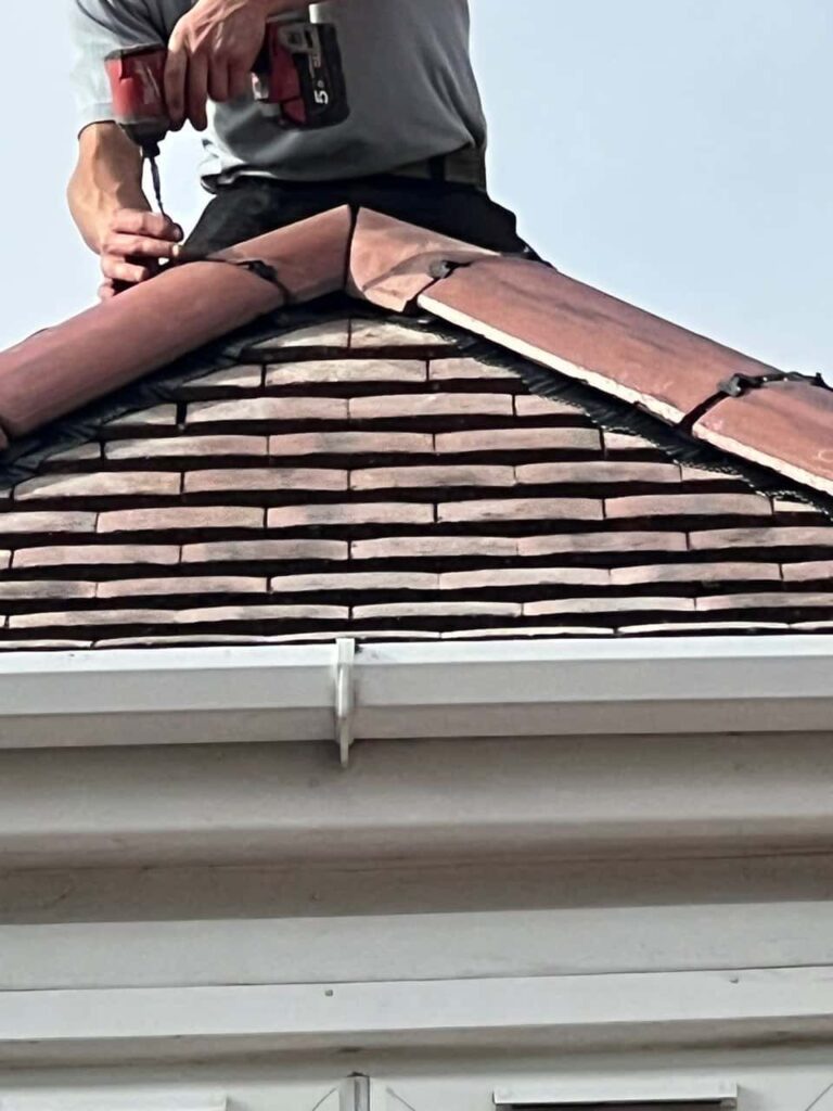 This is a photo of one of the operatives of Mildenhall Roofing Repairs installing new ridge tiles